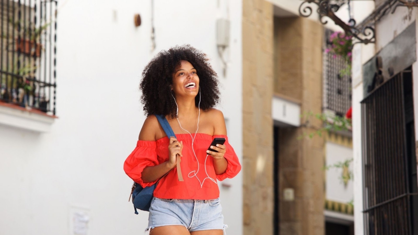 Image of a young woman smiling while talking on the phone. This image illustrates how happy college students can feel after working with an online therapist in Nashville, TN. Young adults across the state can meet with one using online therapy in Tennessee. | 37203 | 37383