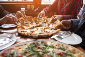 Image of a group of friends eating pizza together. This image depicts how anxiety treatment in Nashville, TN can help college students get out of their comfort zone. | 37212 | 37215