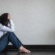 Image of a woman sitting on the ground with her hands on her head. This image represents the frustration college students feel with anxiety symptoms before starting anxiety treatment in Nashville, TN. 37130 | 37916