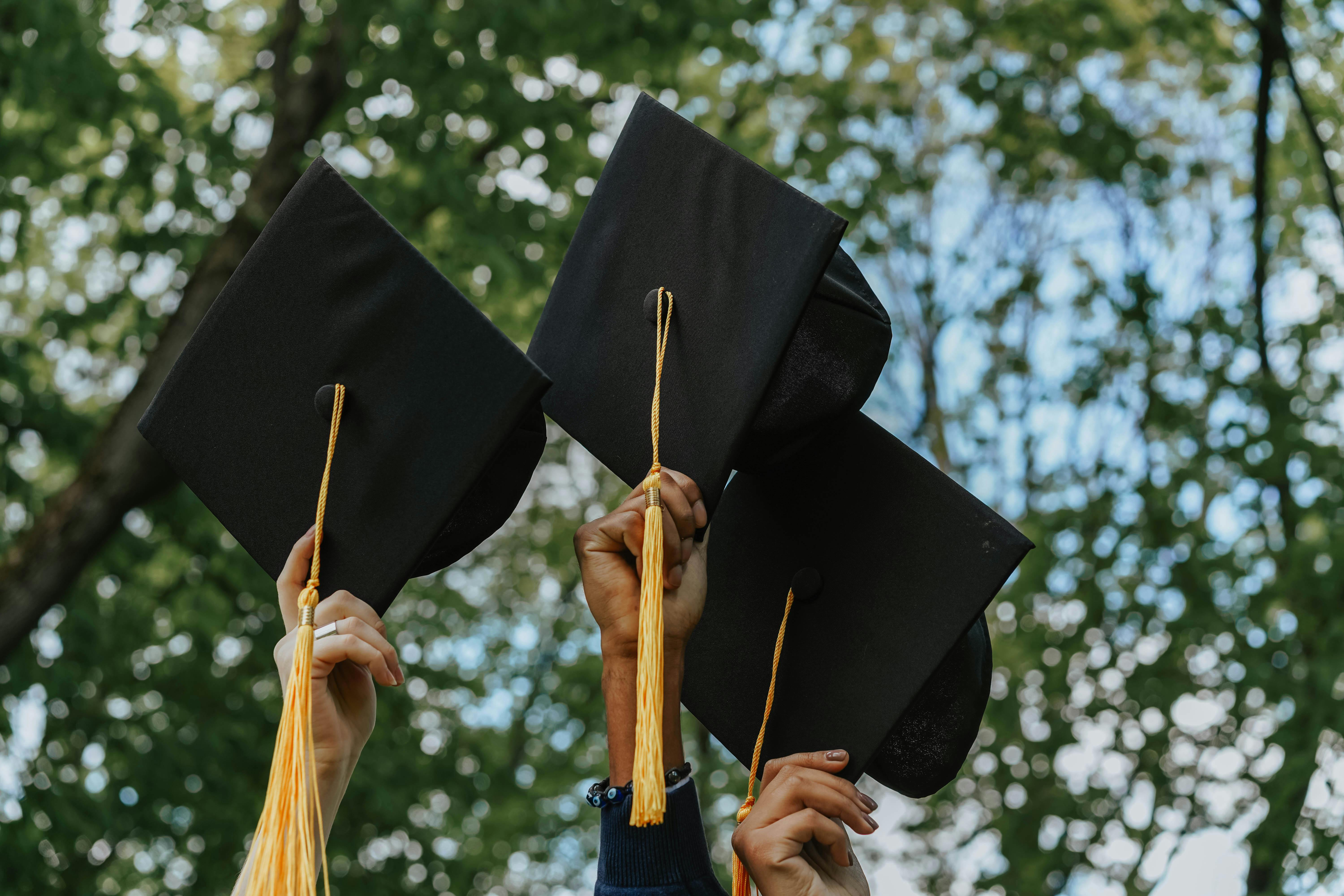 Graduation caps being held in the air representing how college students may feel after seeking therapy for senioritis in Tennessee | 37130 | 37916